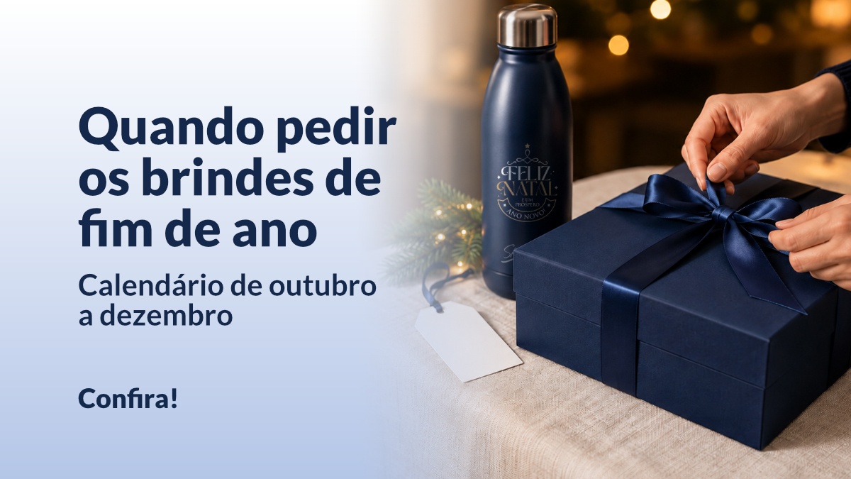 Mãos amarram a fita de um kit corporativo azul-marinho em um ambiente com luzes de fim de ano.